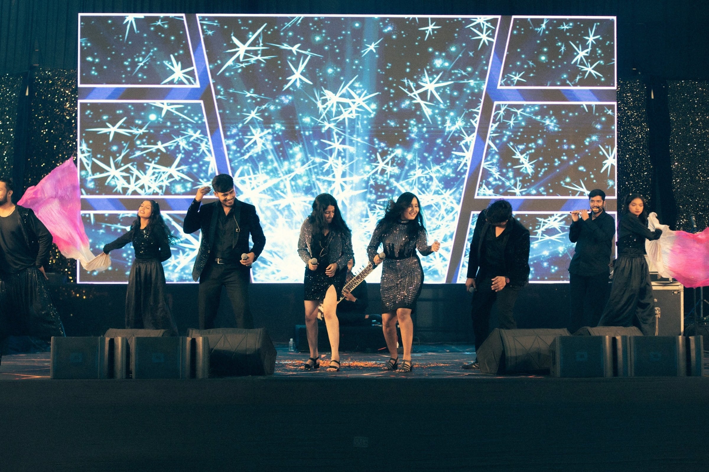 The Urban Strings on stage at a corporate evening in Gandhidham, a glittering LED wall behind the band